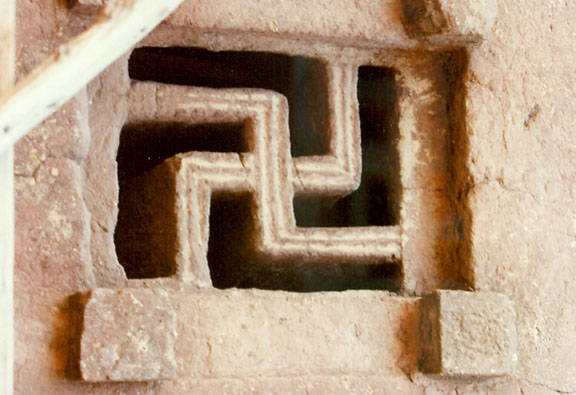 نماد سواستیکا در پنجره‌ی کلیسای سنگی لالیبلا در اتیوپی. 